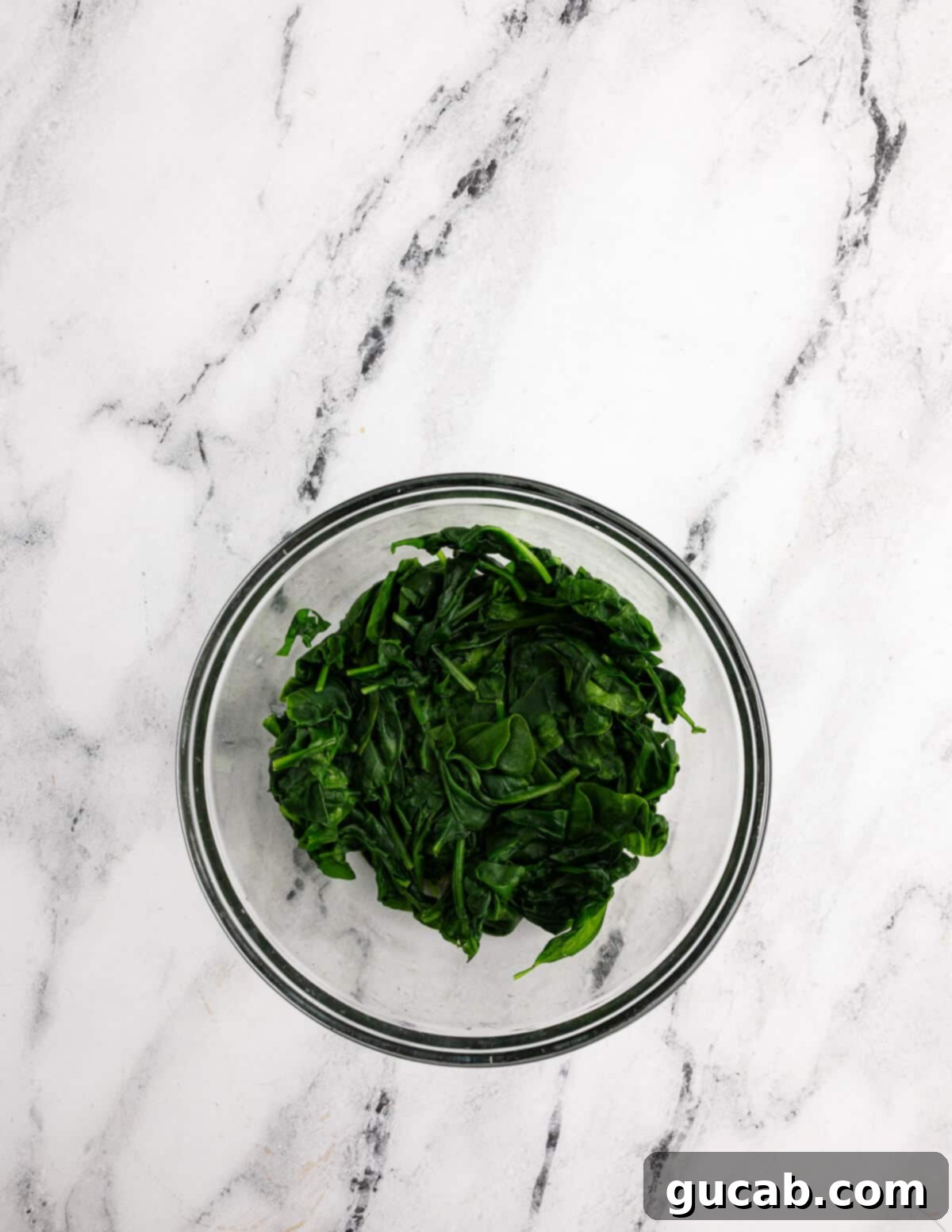 a bowl of cooked baby spinach. 