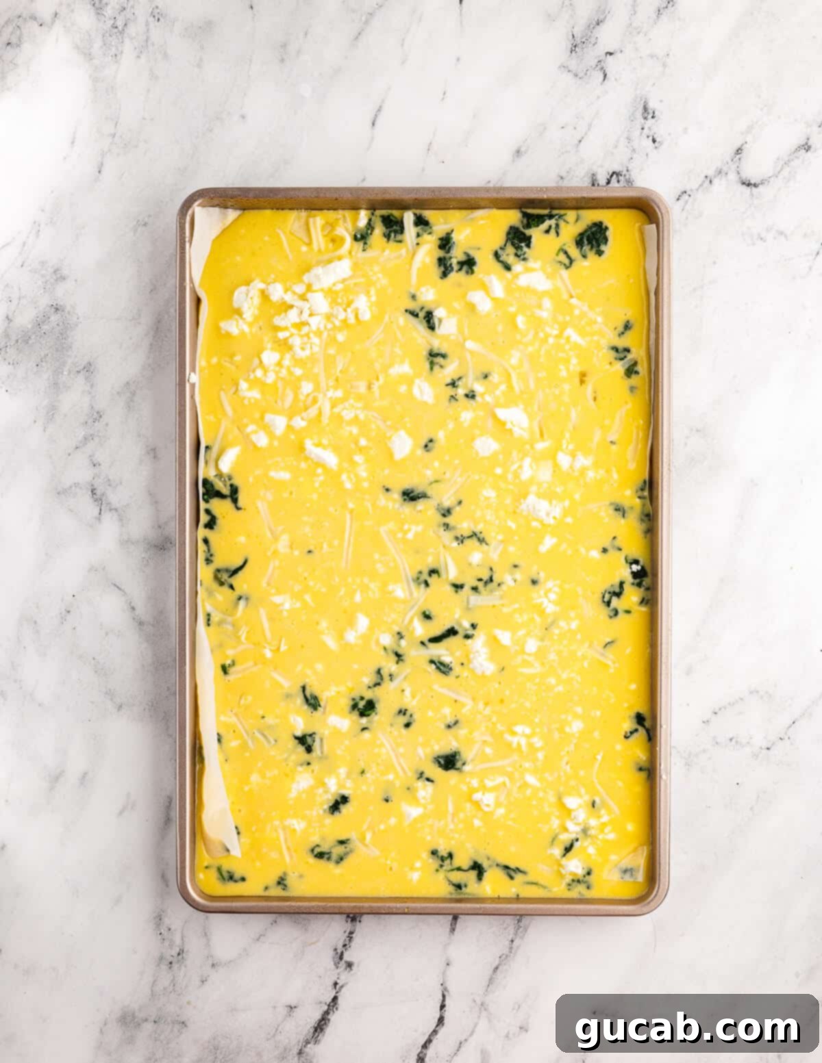 whisked eggs, spinach, and feta in a sheet pan. 