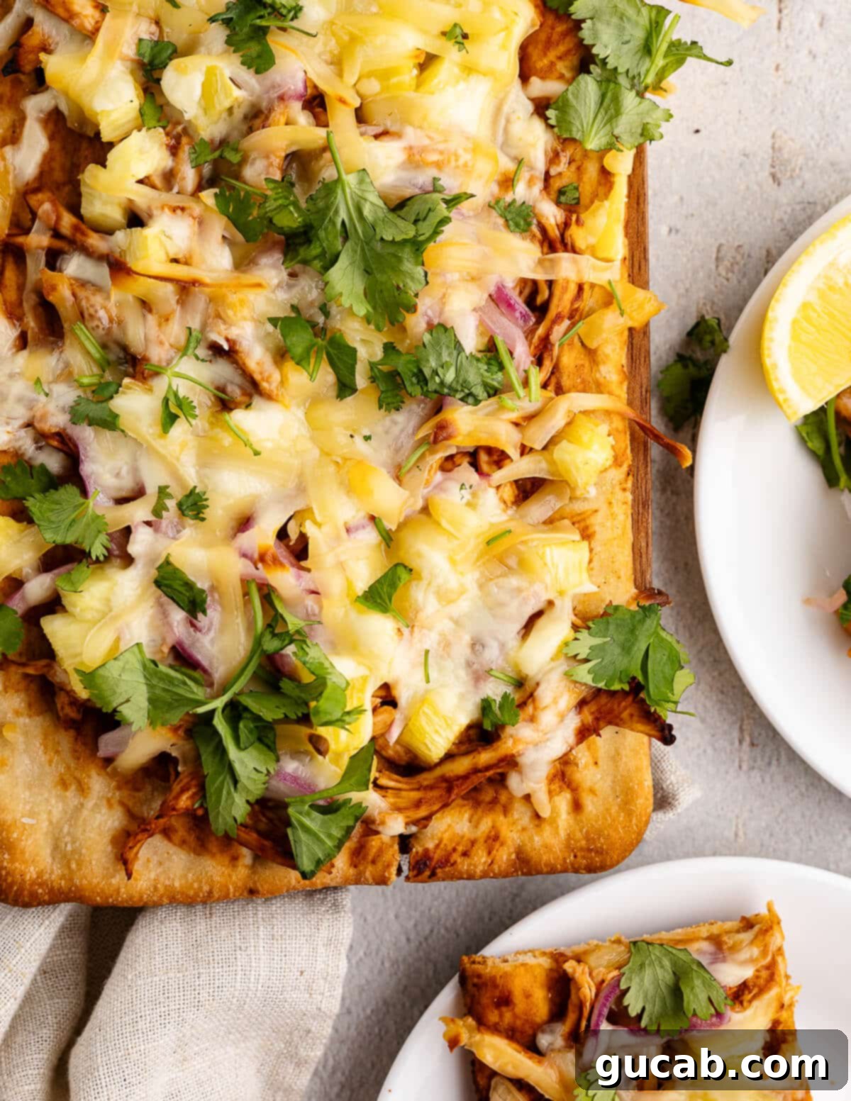 A freshly baked Hawaiian barbecue chicken flatbread on a wooden cutting board, with vibrant toppings visible, ready to be sliced and served.