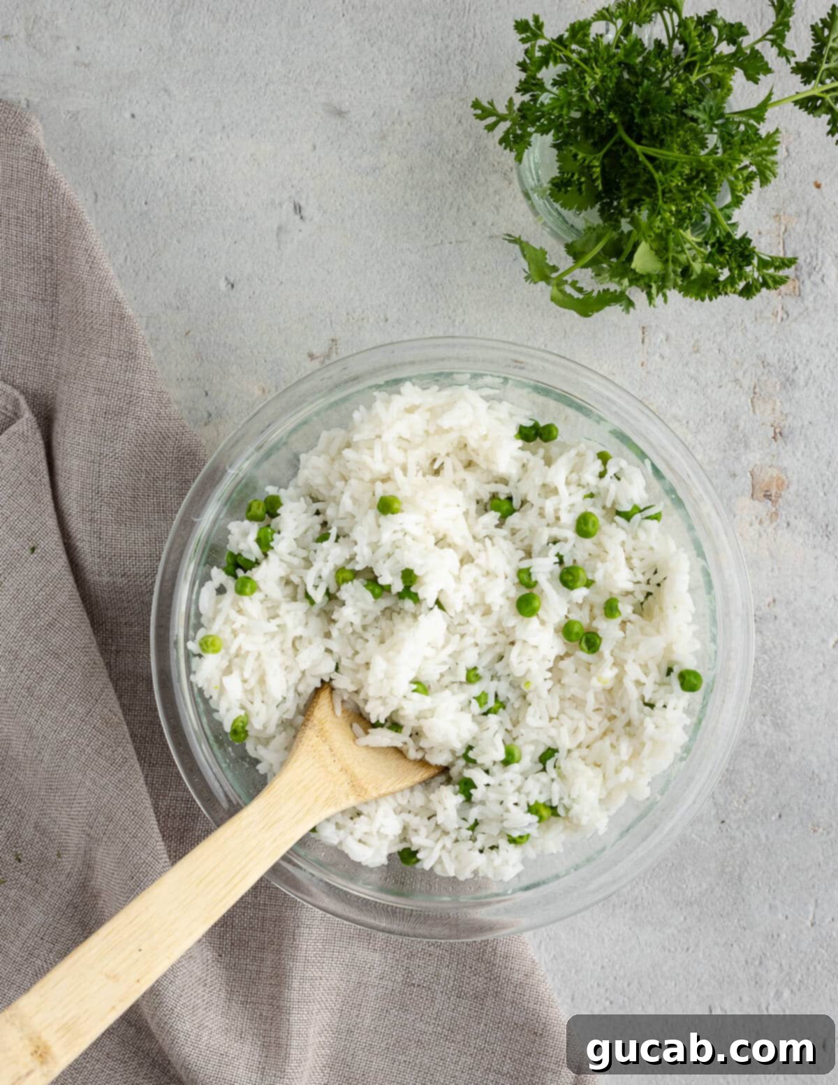 A bowl filled with freshly cooked white rice and bright green peas, just drained.
