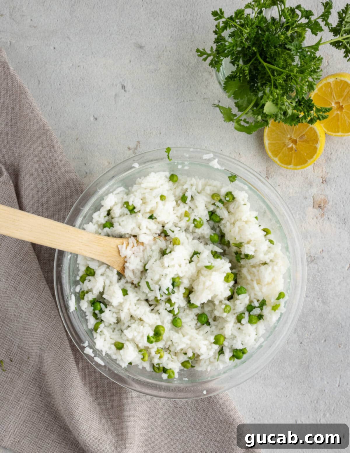 A bowl of cooked white rice and peas, now mixed with a generous amount of fresh herbs, ready to serve.