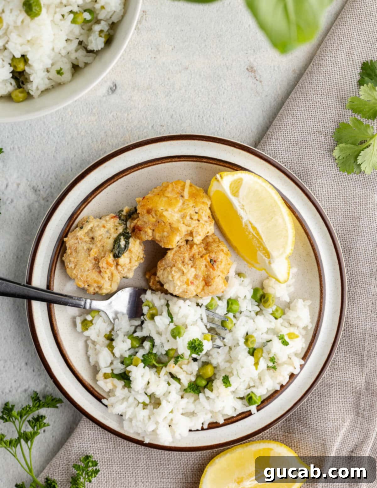 A plate featuring crispy fried chicken alongside a generous portion of fluffy white rice with peas.