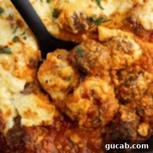 One-Pan Cheesy Meatballs 15 a spoonful of meatballs in sauce with cheese on top.