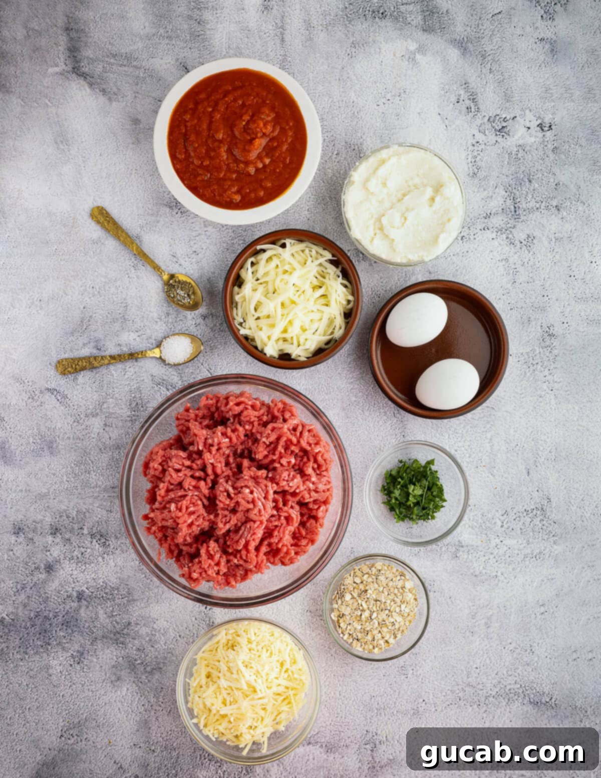 One-Pan Cheesy Meatballs 3 Arrangement of key ingredients: marinara sauce, ricotta cheese, shredded mozzarella, eggs, ground beef, quick oats, fresh parsley.