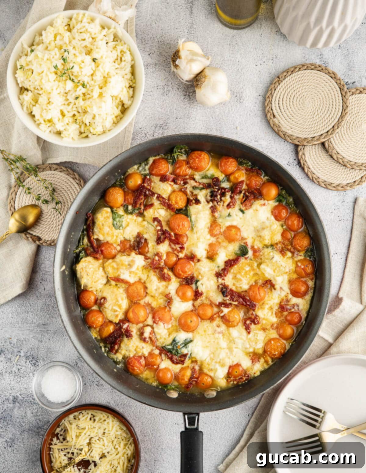 chicken meatballs in a skillet with tomatoes, sun-dried tomatoes, spinach, and ricotta cheese.