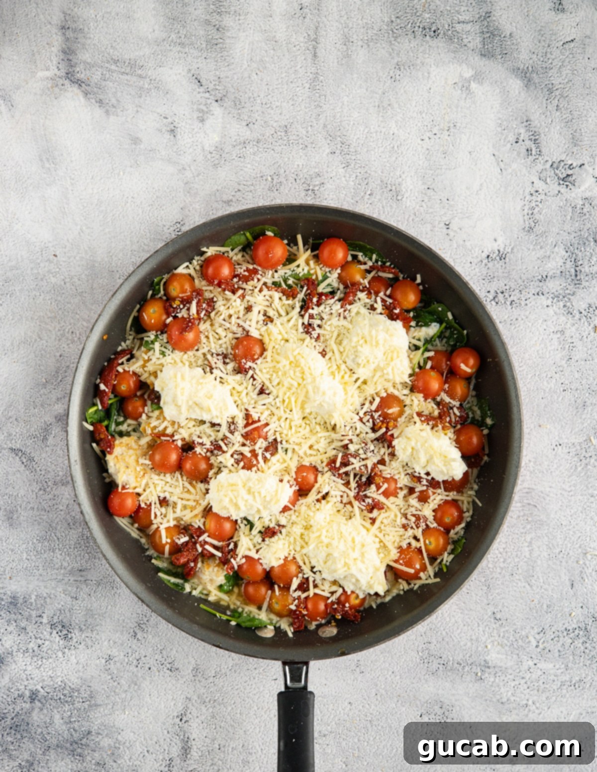 The Ultimate Date Night Chicken Meatballs 13 A skillet with marry me chicken meatballs fully topped with ricotta and parmesan cheese, ready for the oven.