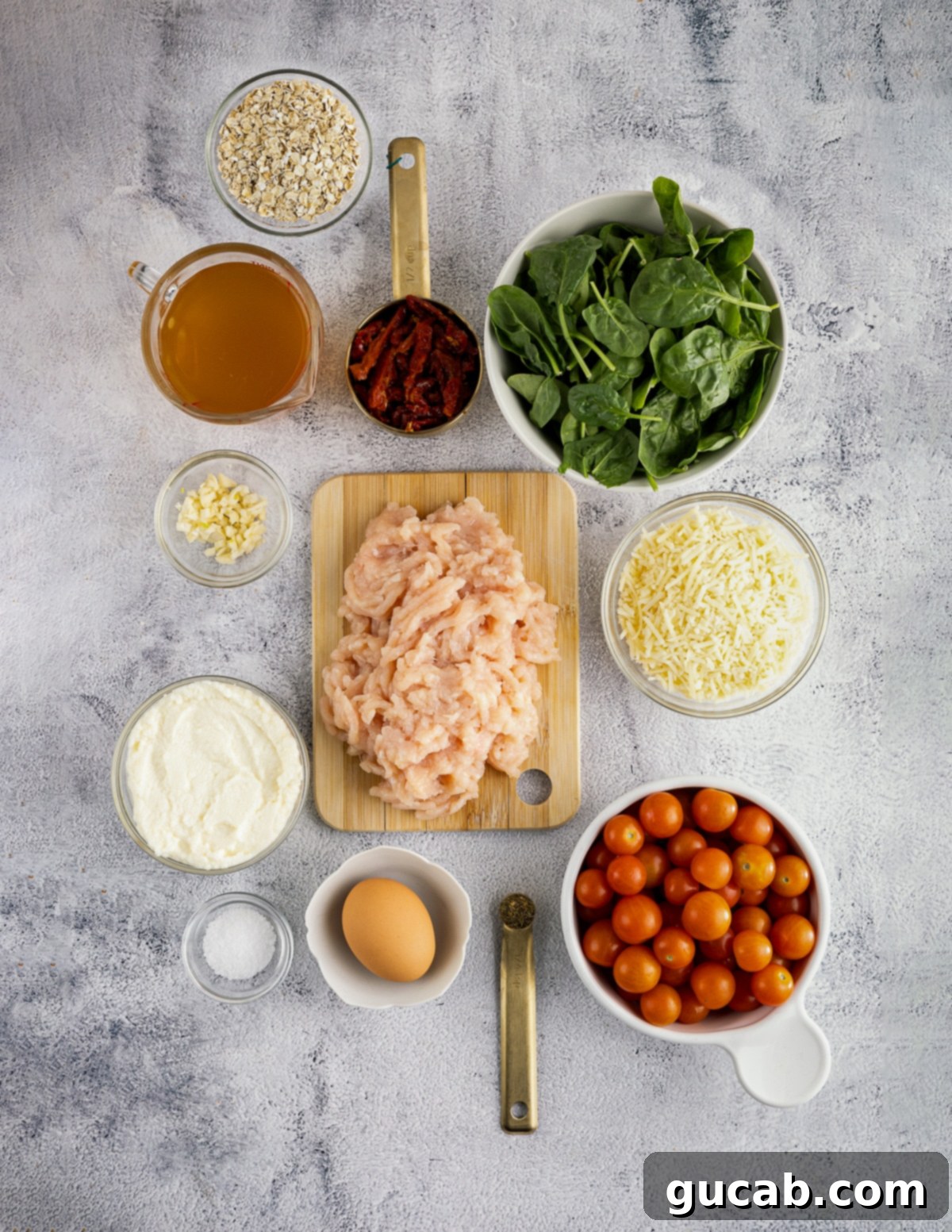 The Ultimate Date Night Chicken Meatballs 3 Quick oats, spinach, chicken stock, sundried tomatoes, parmesan cheese, ricotta cheese, cherry tomatoes, garlic, egg, salt, and ground chicken laid out as key ingredients.