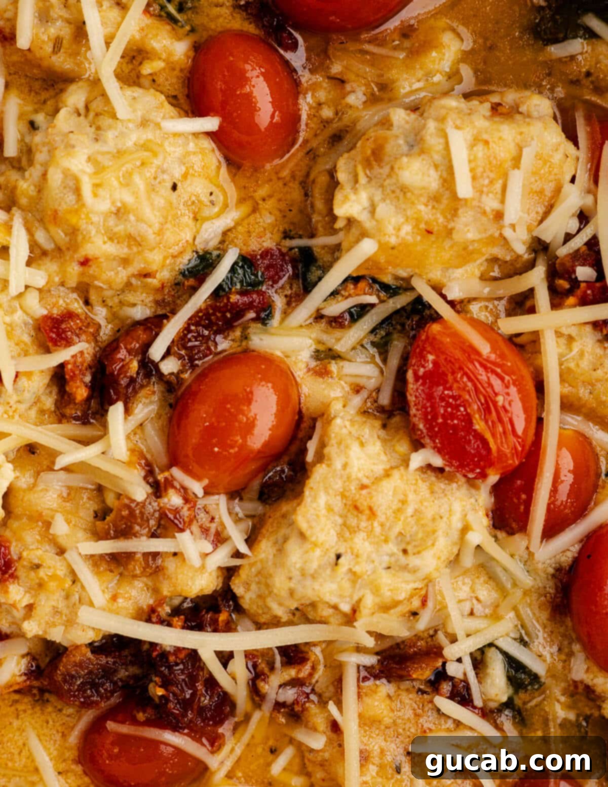 close up of marry me chicken meatballs with tomatoes, sundried tomatoes, and parmesan. 