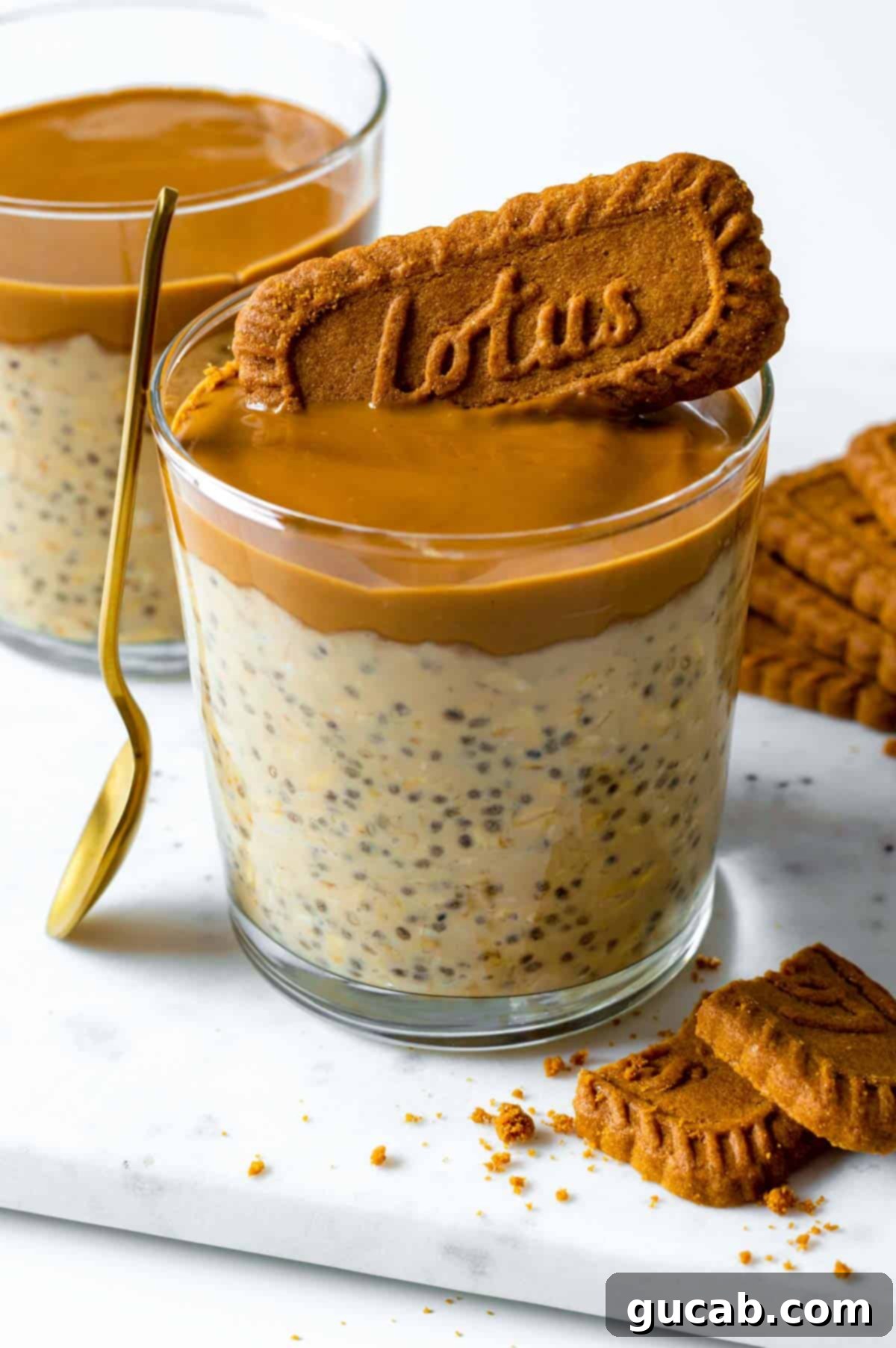 A glass jar filled with creamy Biscoff overnight oats, topped with a generous swirl of Biscoff spread and a crushed Biscoff cookie for extra flavor and crunch.