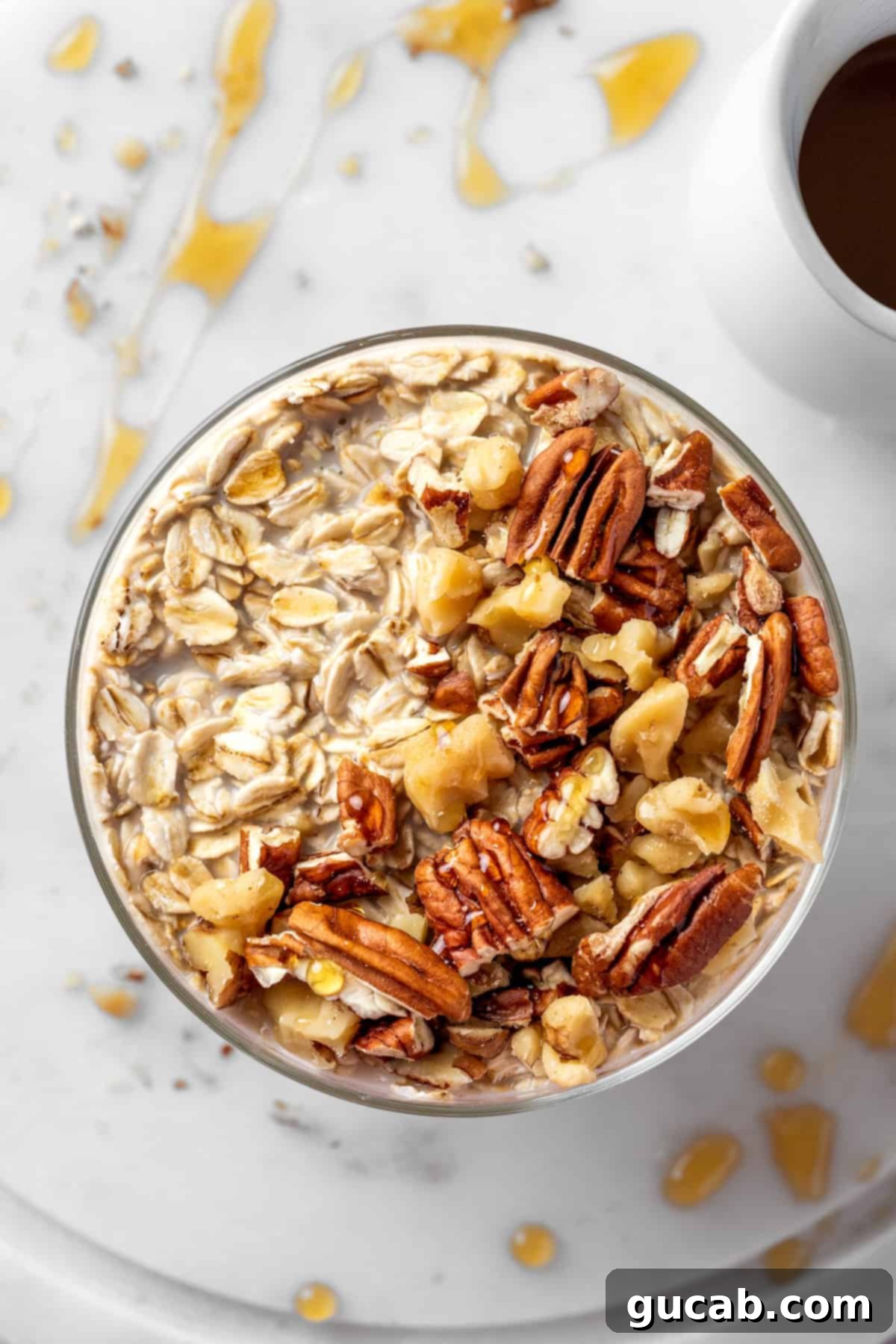 The top view of a glass jar filled with creamy maple brown sugar overnight oats, garnished with a sprinkle of pecans and walnuts for added crunch and flavor.