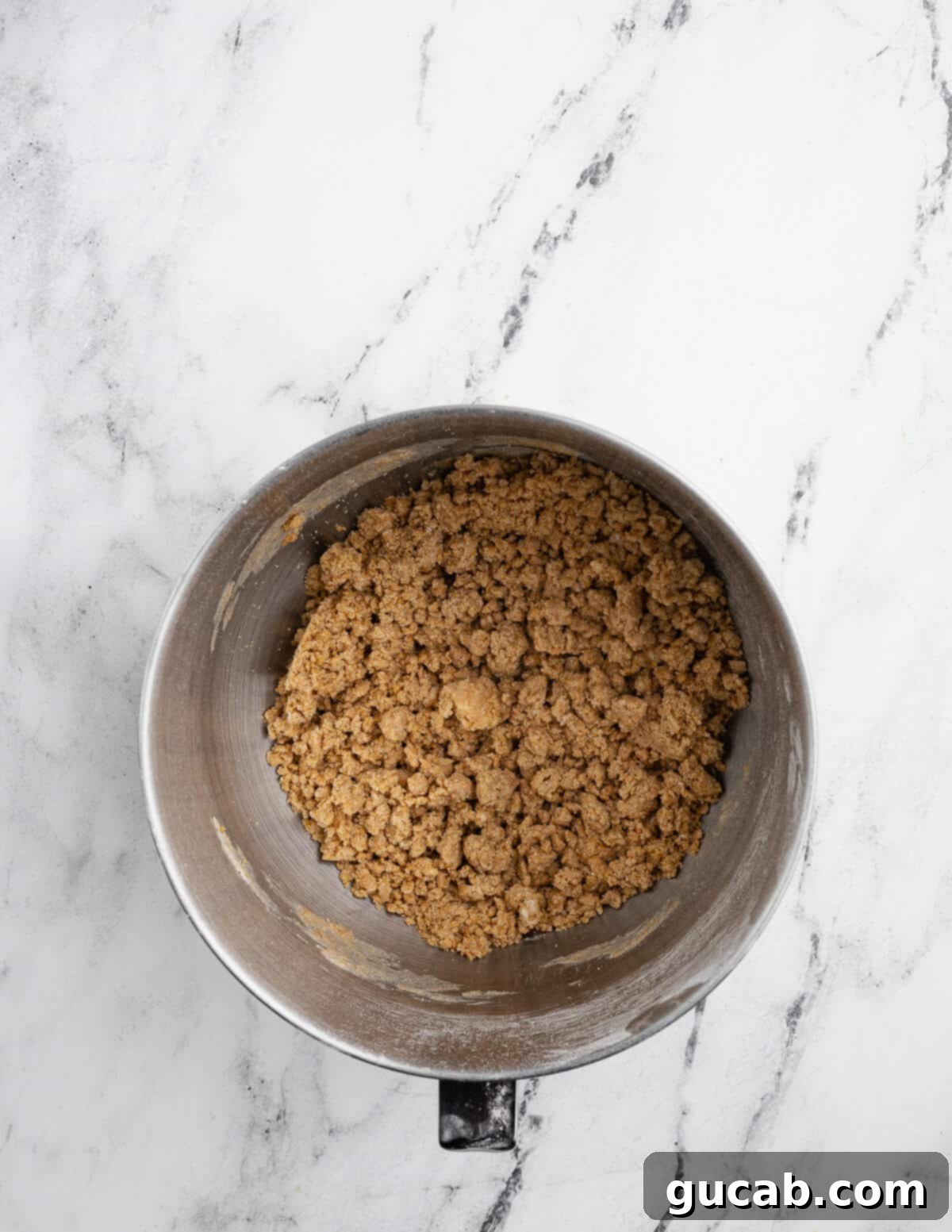 Golden Gluten-Free Graham Delights 7 a mixing bowl with graham cracker cookie dough in crumbles, before fully combining.