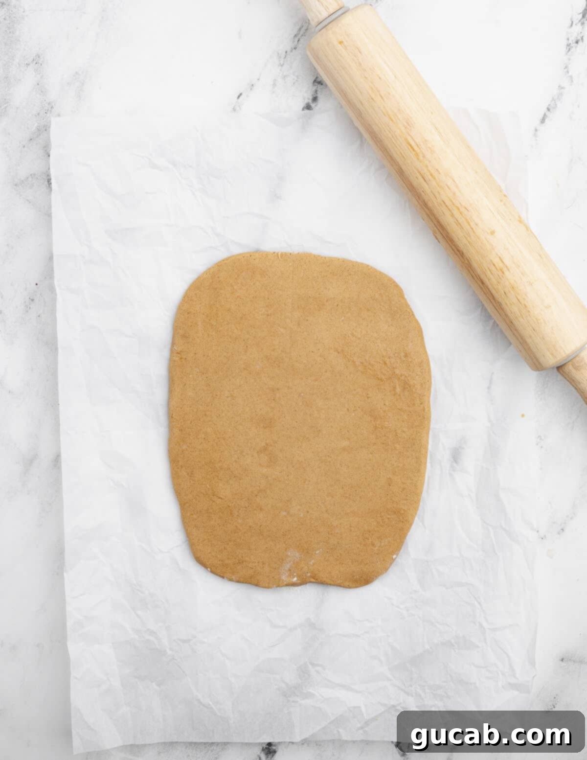 Golden Gluten-Free Graham Delights 9 rolled out gluten-free cookie dough shaped into a rectangle, with a rolling pin nearby.