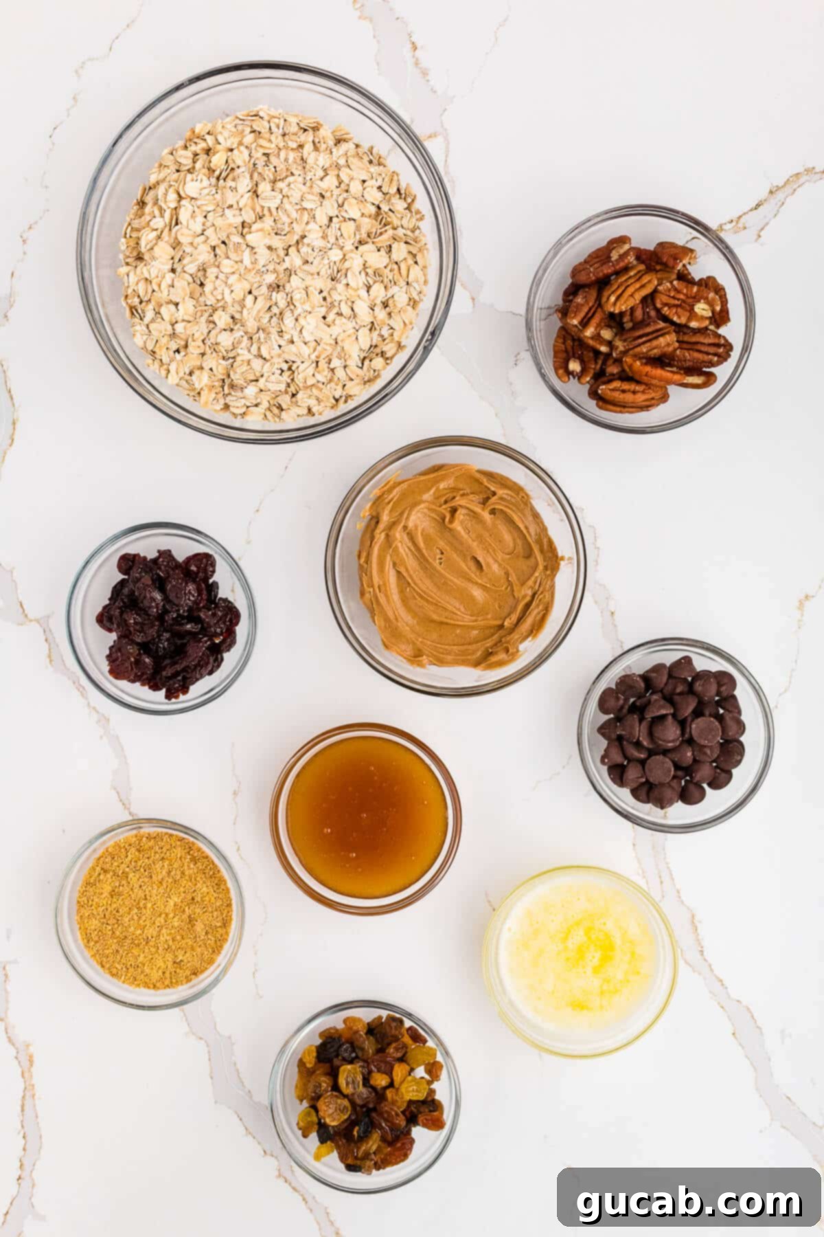 A vibrant selection of ingredients for homemade granola bars, including whole oats, crunchy pecans, creamy peanut butter, tart dried cherries, sweet chocolate chips, golden honey, nutritious golden flax meal, juicy golden raisins, and rich melted butter.