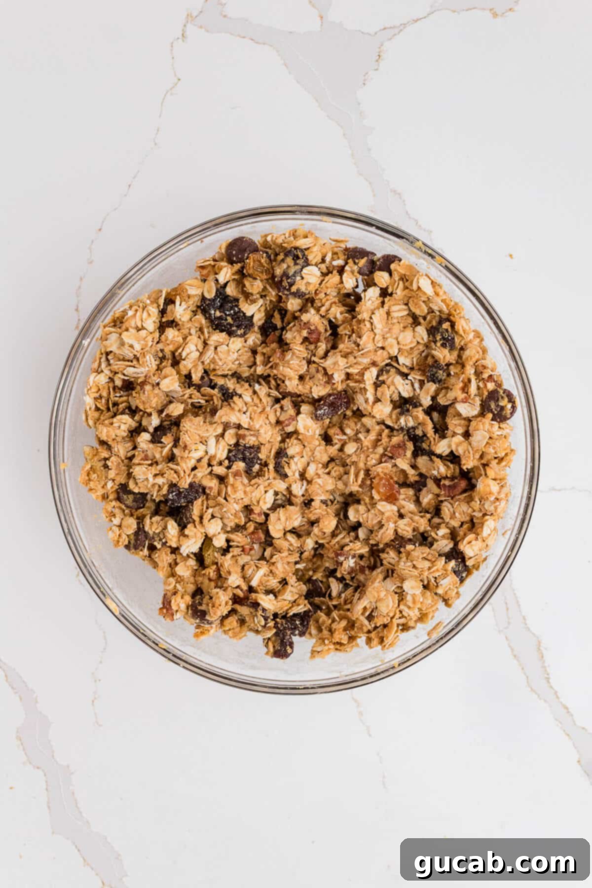 The thoroughly mixed granola bar dough, a cohesive and uniform blend of oats, peanut butter, and honey, now ready for pressing into the pan.