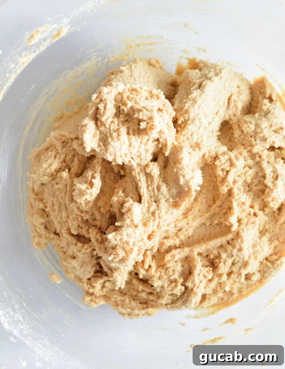 A bowl of soft peanut butter cookie dough made with almond flour, before chocolate chips are added.