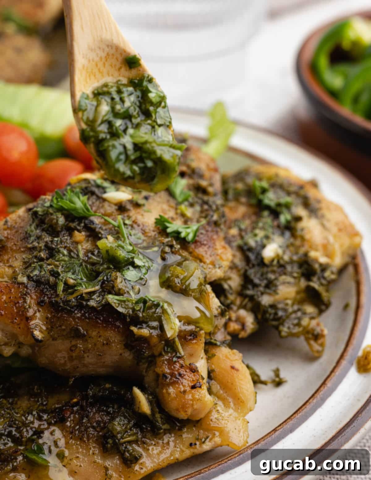 Zesty Chimichurri Chicken Thighs 2 Drizzling fresh chimichurri onto succulent chimichurri chicken thighs, highlighting the vibrant herbs and juicy texture.