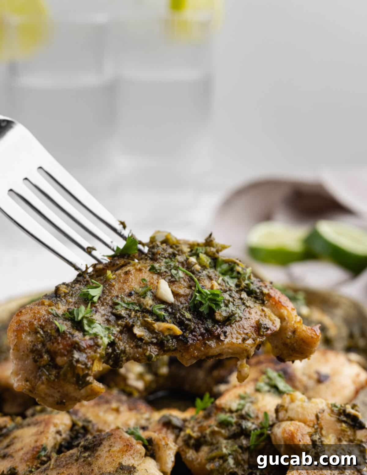 Zesty Chimichurri Chicken Thighs 4 A close-up shot of a fork holding a perfectly cooked chimichurri chicken thigh, generously covered in the vibrant green sauce, ready to be enjoyed.