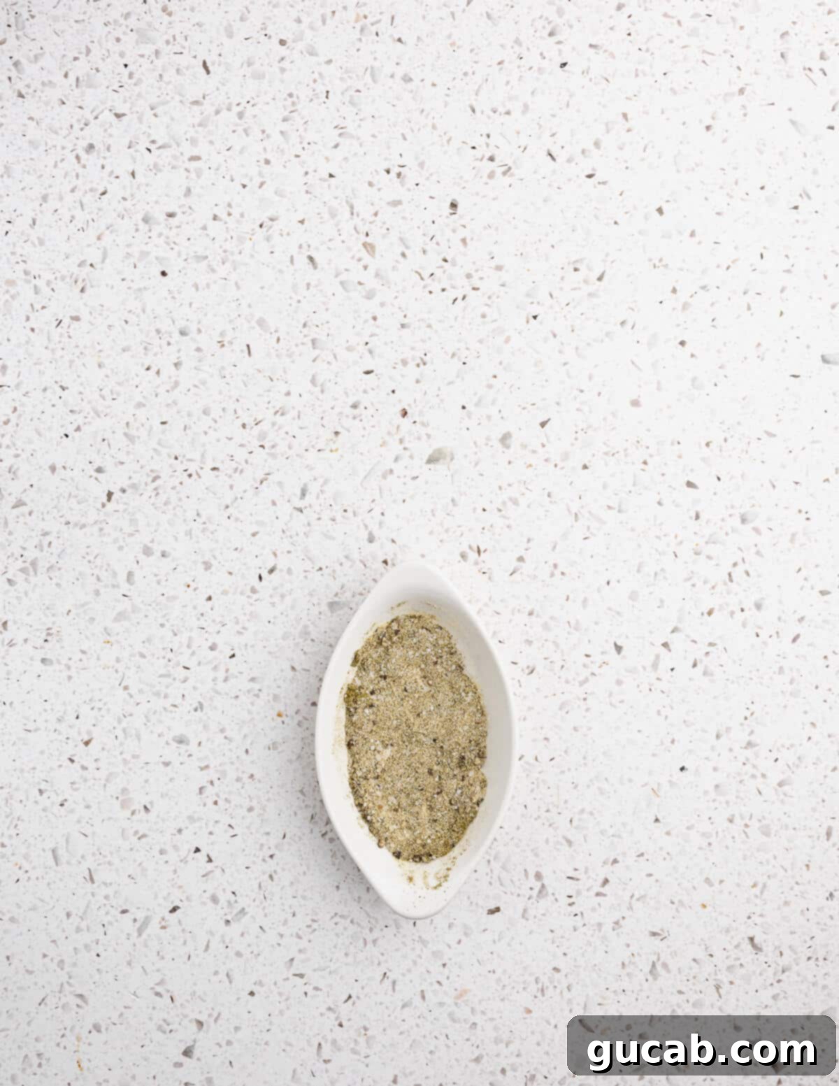 Zesty Chimichurri Chicken Thighs 7 A small dish holding a carefully measured seasoning blend of onion powder, garlic powder, kosher salt, black pepper, and oregano.