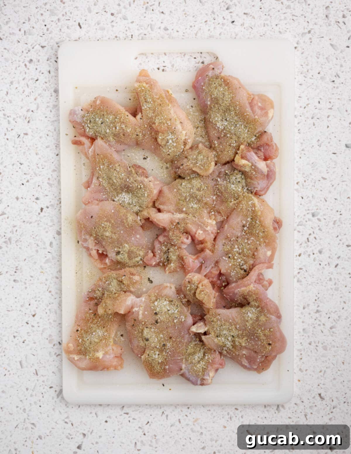 Zesty Chimichurri Chicken Thighs 8 Raw chicken thighs uniformly coated in a savory seasoning blend, ready for searing.