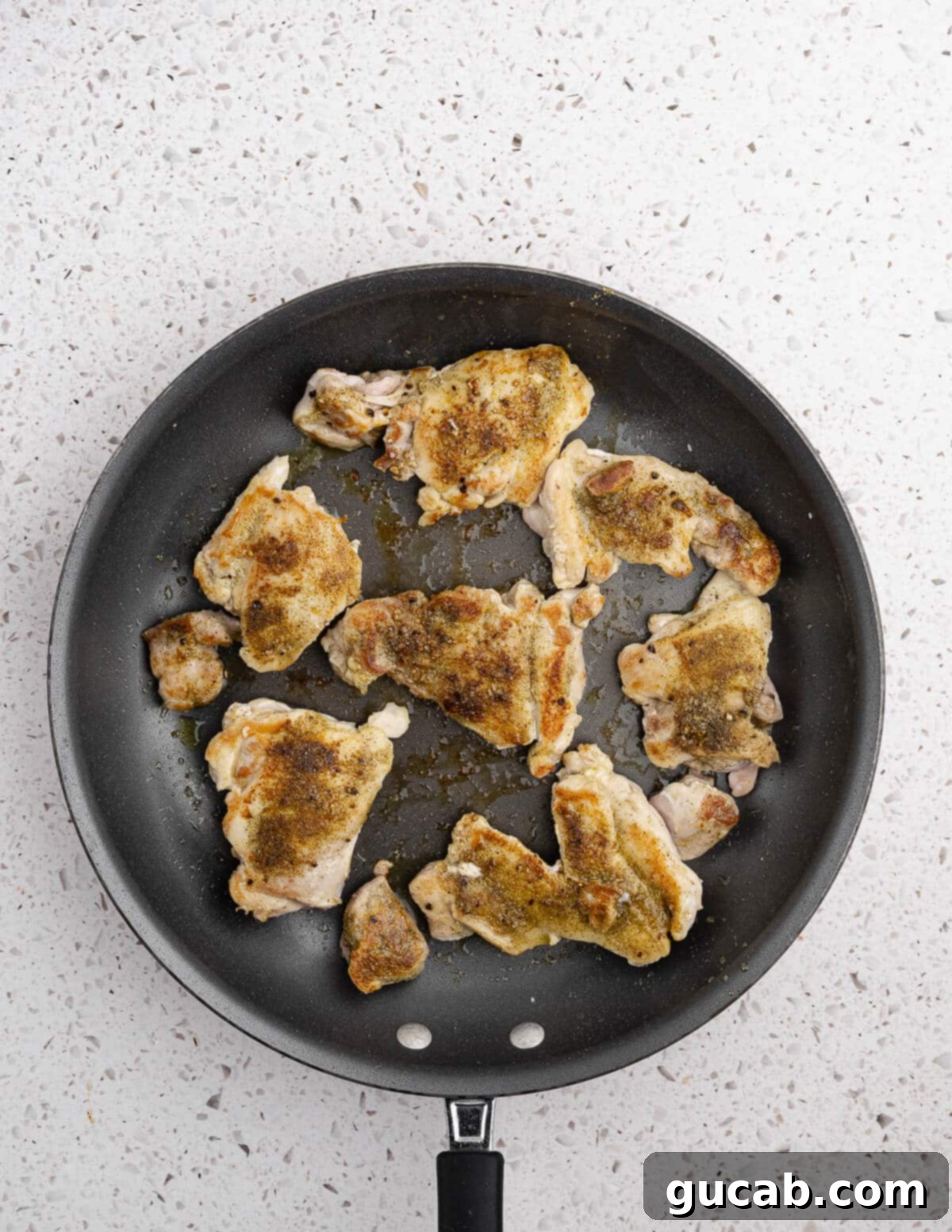 Zesty Chimichurri Chicken Thighs 9 Perfectly caramelized chicken thighs sizzling in a hot skillet, showcasing their golden-brown crust.
