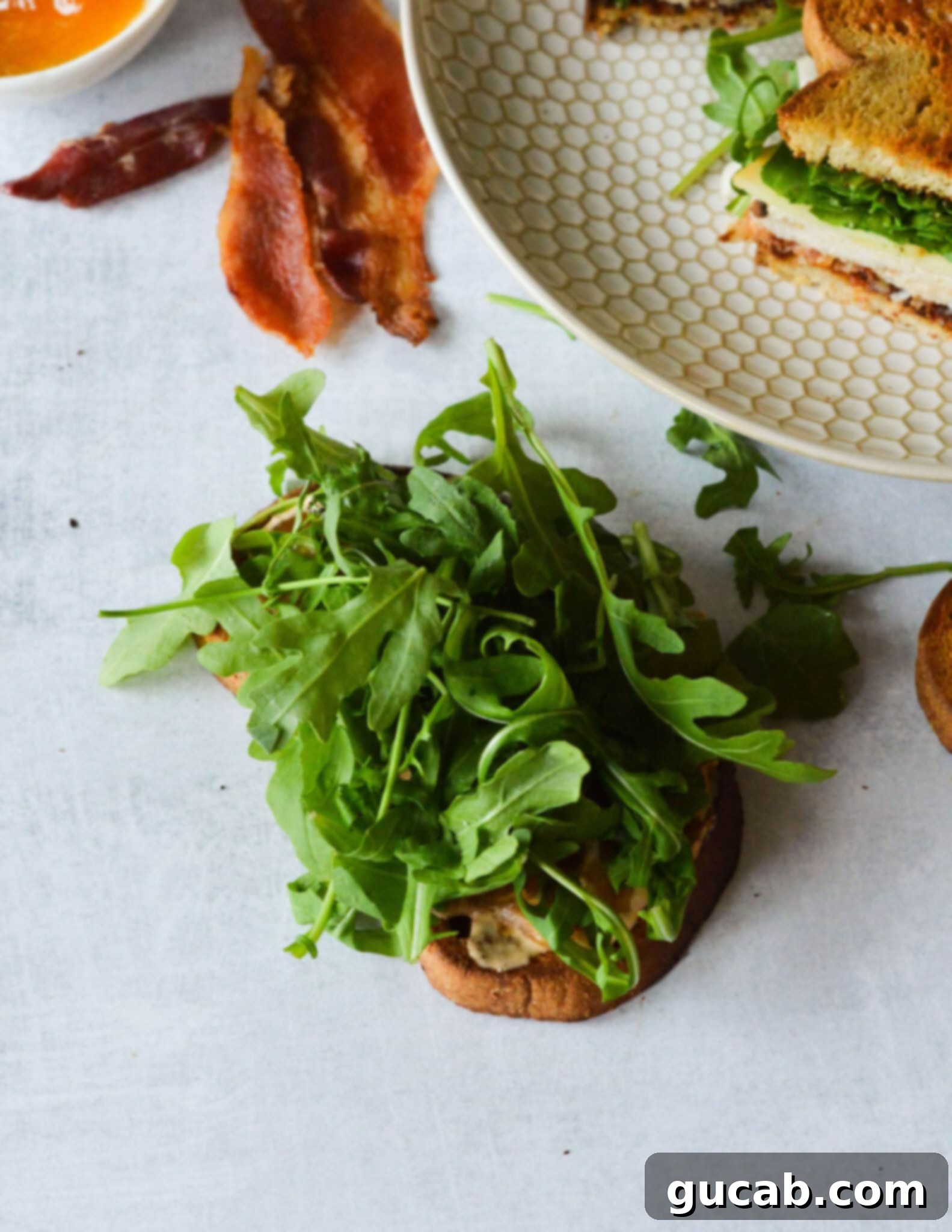 A piece of golden-brown toasted sourdough bread topped with a generous layer of fresh arugula.