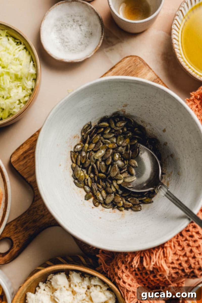 A bowl of pepitas, chili powder, brown sugar, and maple syrup, thoroughly mixed and coated.