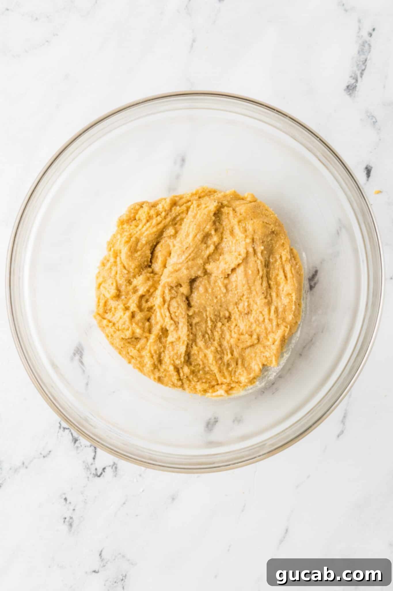 A bowl filled with freshly mixed cornmeal cookie dough, ready for scooping and baking.