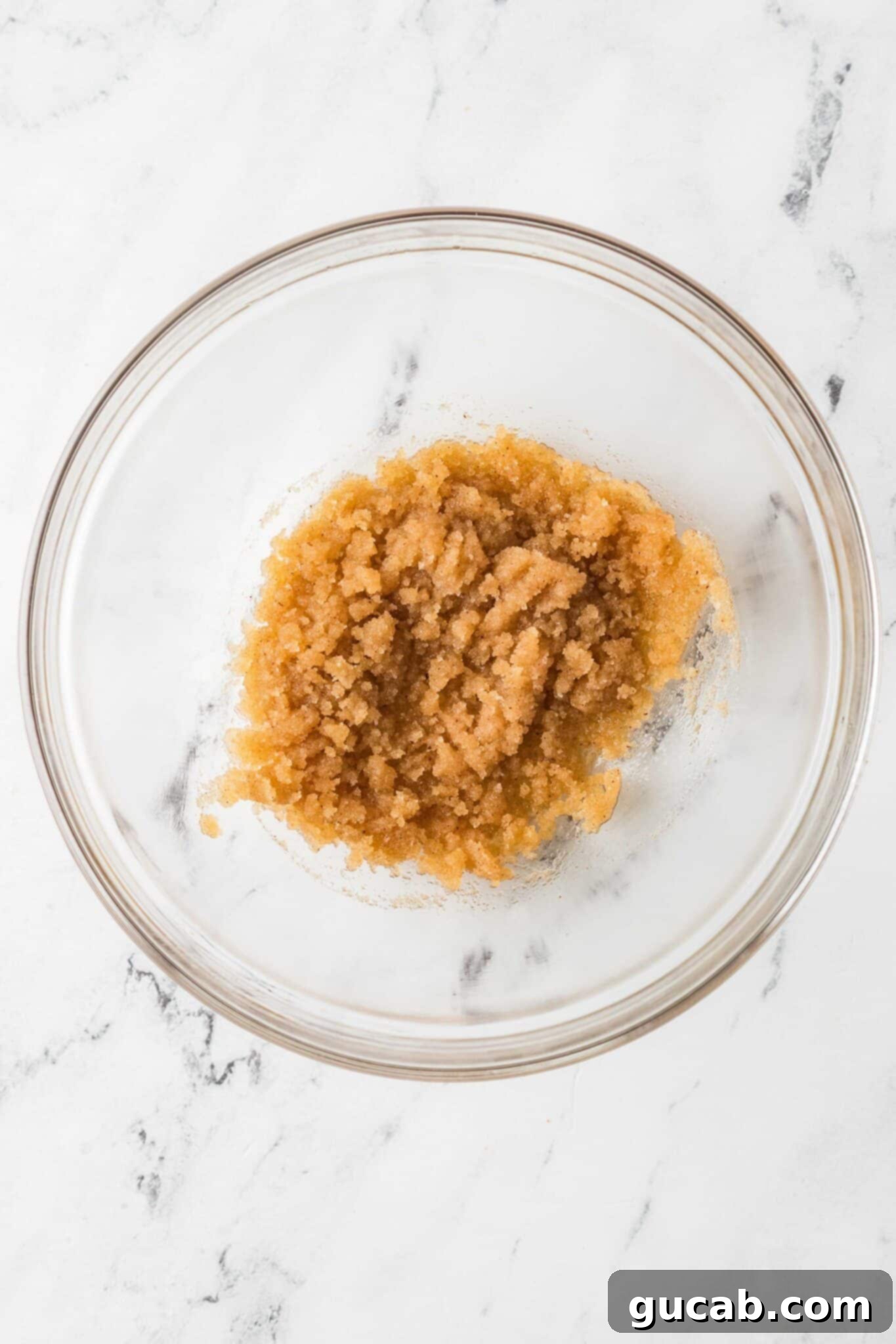 Brown sugar, white sugar, and browned butter expertly mixed together in a bowl, forming a smooth base for the cookie dough.