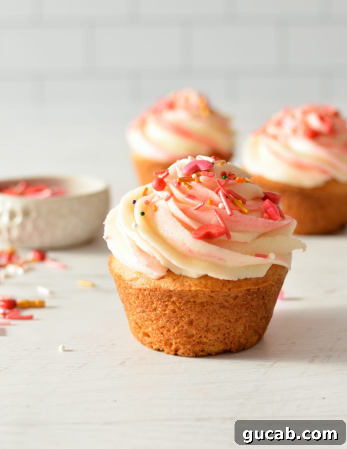 Delicious gluten-free vanilla cupcake topped with creamy frosting and colorful sprinkles.