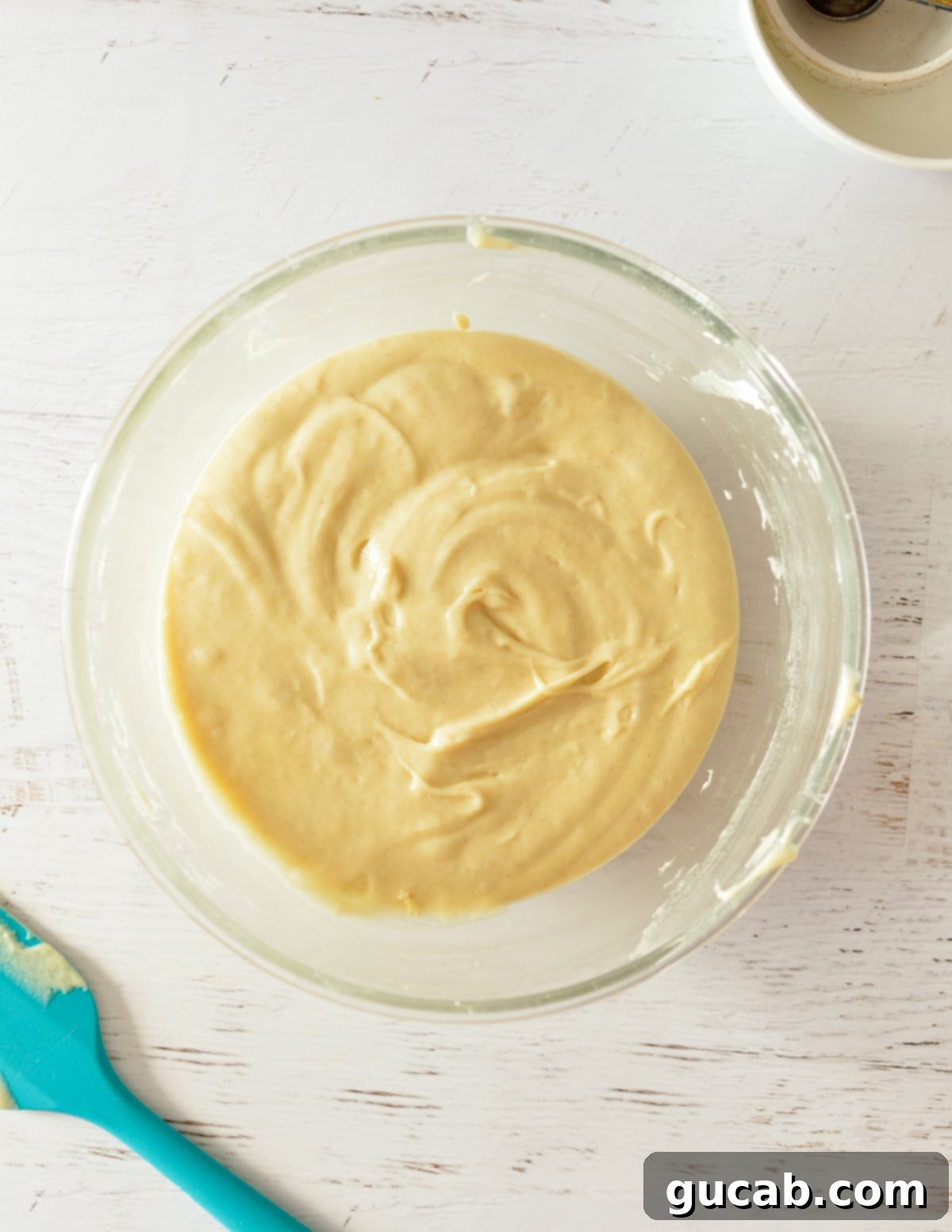 A bowl of finished, smooth gluten free cake batter, ready for baking.