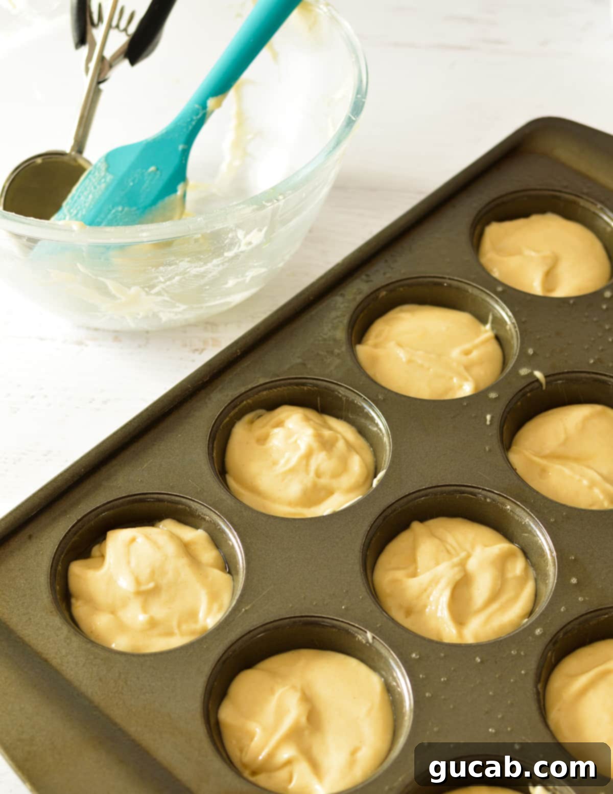 Gluten free cupcake batter scooped into a cupcake tin, filled to the correct level.