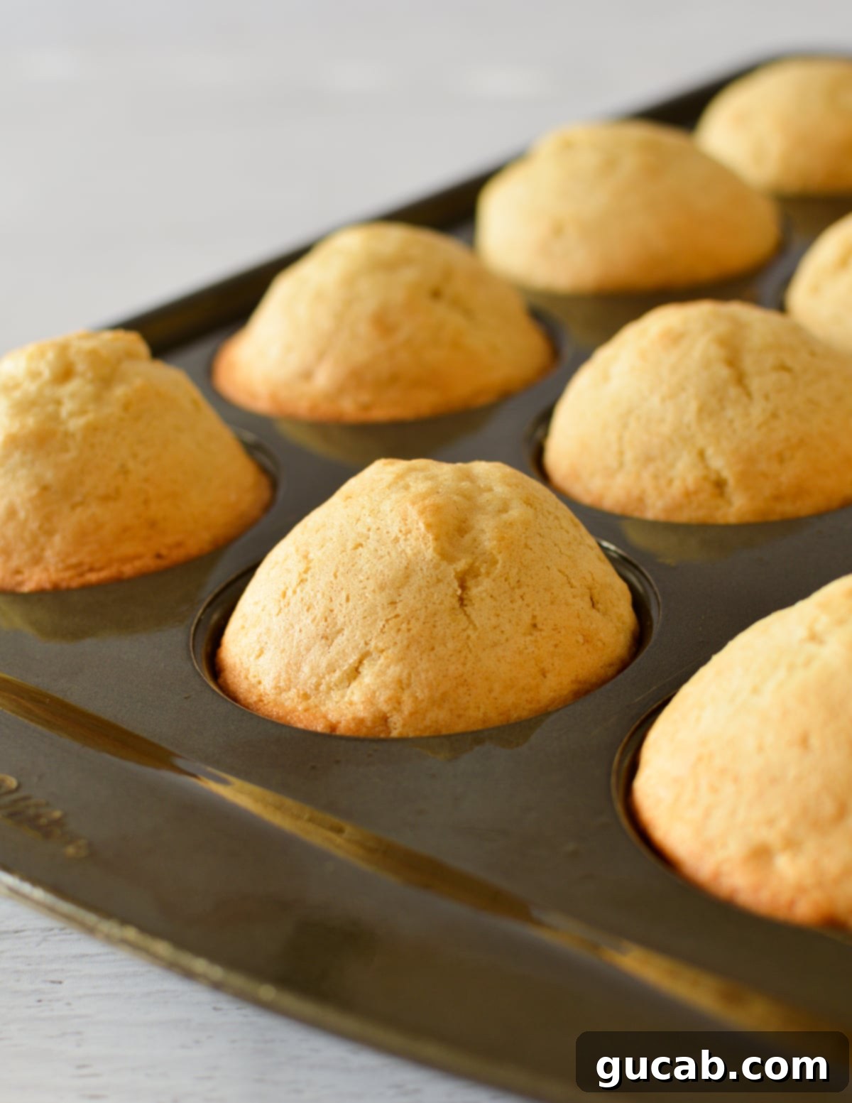 Gluten free cupcakes baking in a tin, showing good rise.