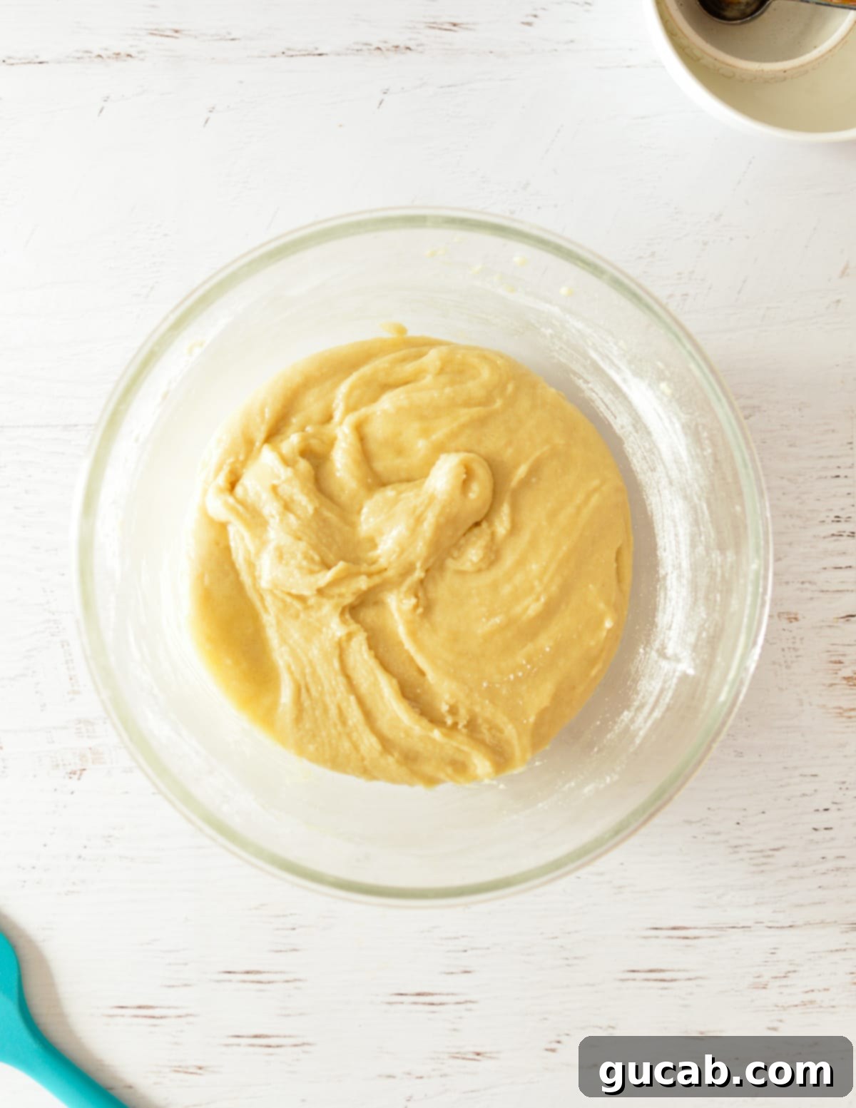 A bowl of smooth gluten free cake batter after dry ingredients are mixed in.