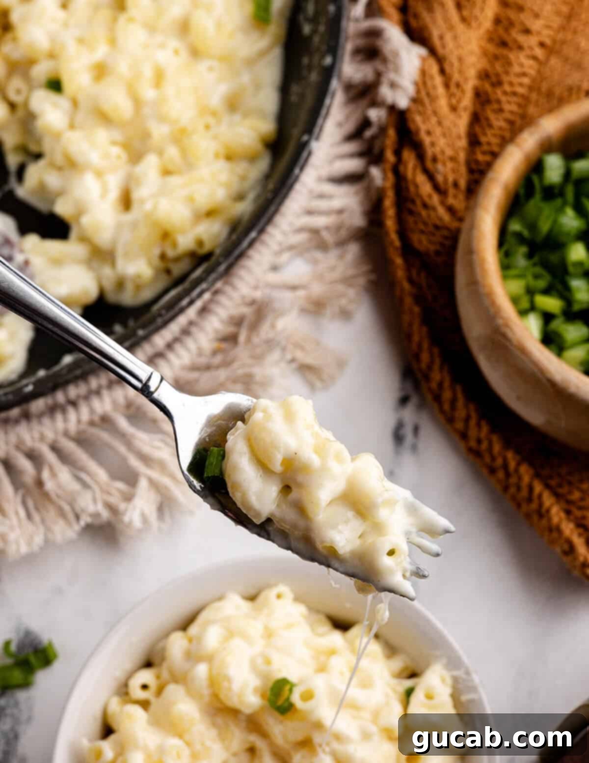 A close-up shot of a forkful of perfectly cooked gluten-free macaroni and cheese, showing the creamy texture and melted cheese.