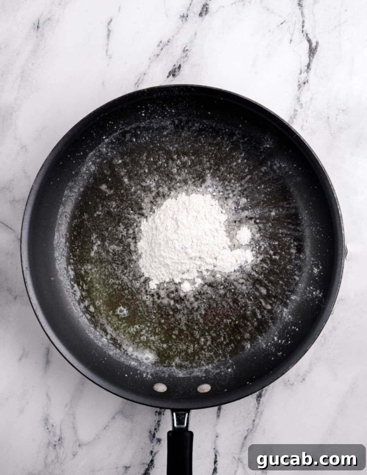 Melted butter in a skillet, ready for gluten-free flour to be added for the roux.