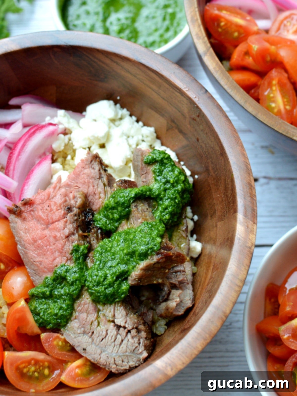 Close-up of vibrant green chimichurri sauce drizzled generously over sliced steak, ready to be served.