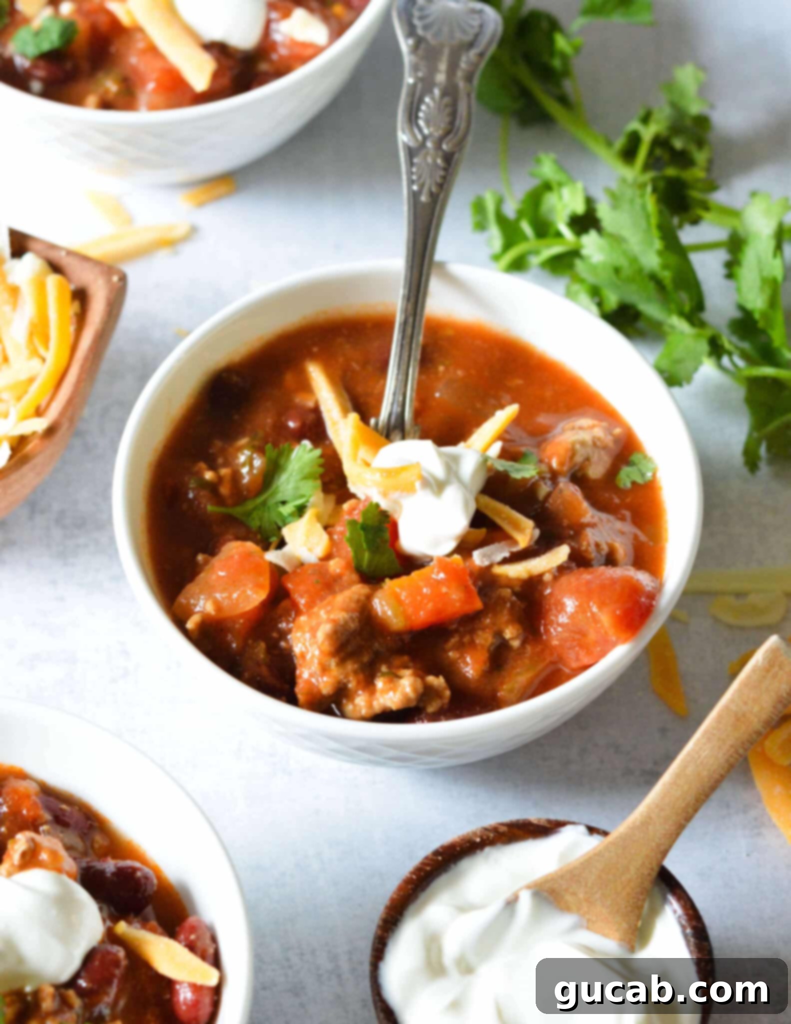 a bowl of turkey chili with sour cream on top. 