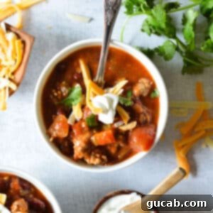 turkey chili in a bowl with shredded cheese and sour cream.