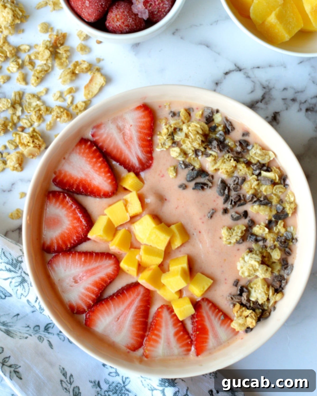 Tropical Strawberry Mango Smoothie Bowl 2 Vibrant strawberry mango smoothie bowl topped with fresh fruit, granola, and cocoa nibs, ready to eat.