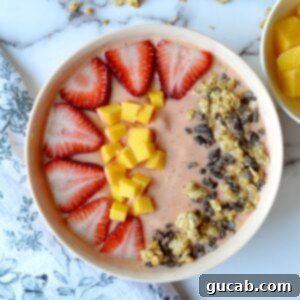 Tropical Strawberry Mango Smoothie Bowl 4 A beautifully presented strawberry mango smoothie bowl, ready to be enjoyed.