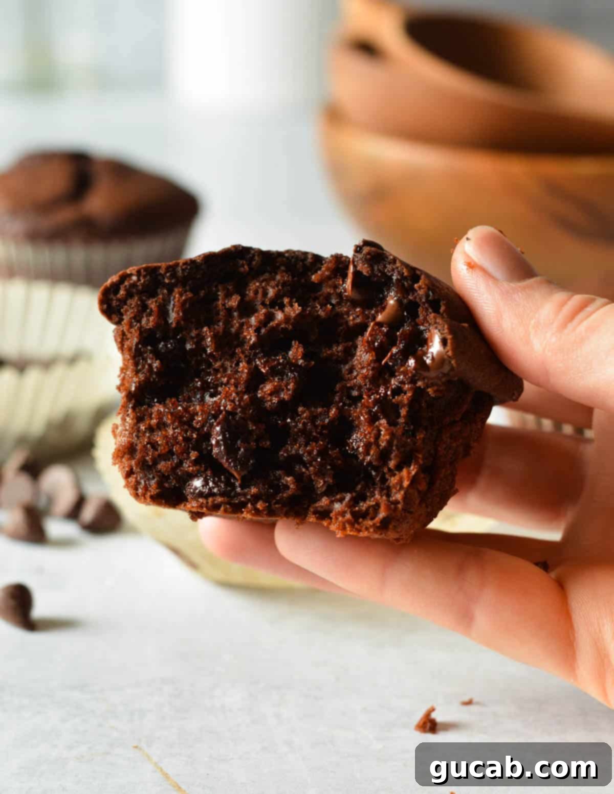 hand holding half a gluten free chocolate muffin. 