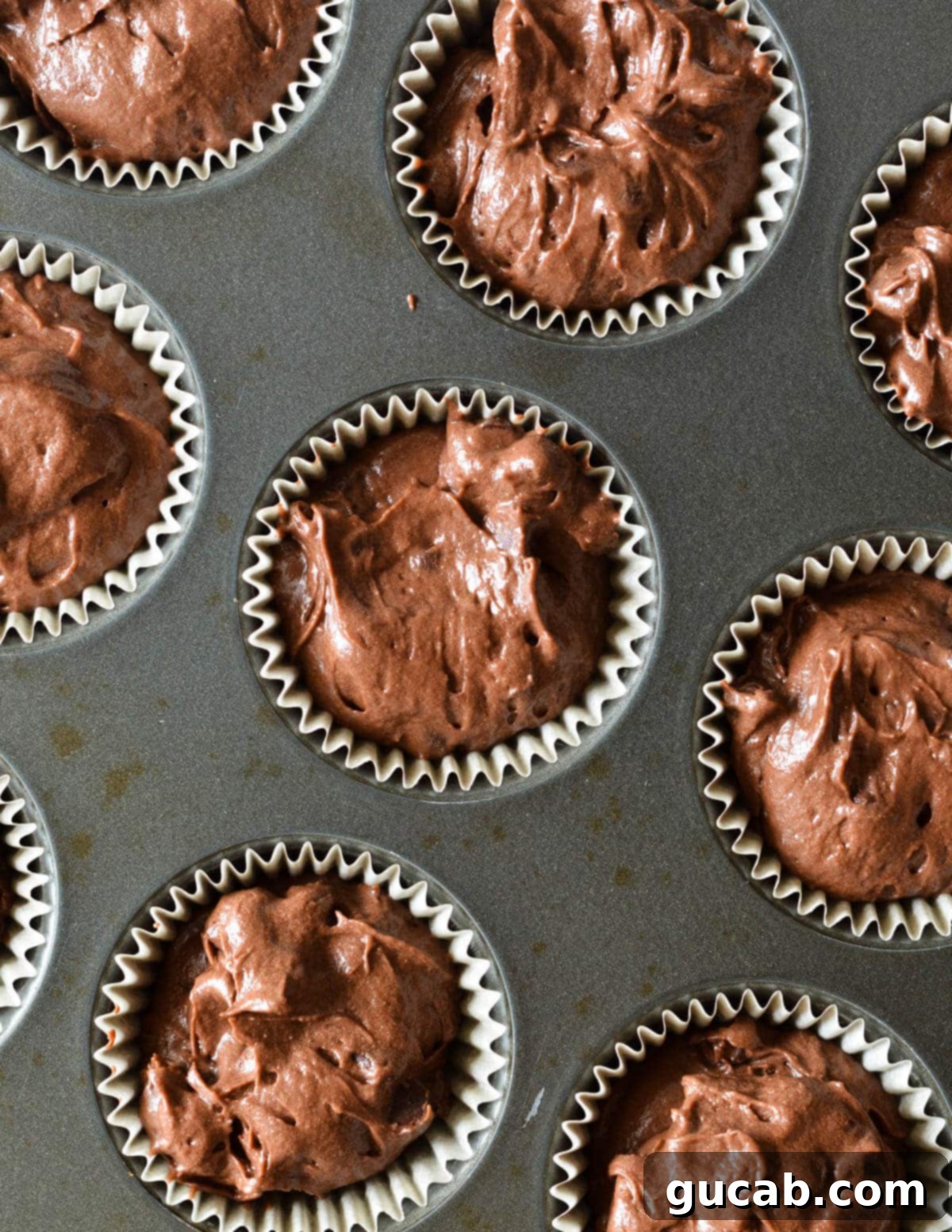 unbaked chocolate muffins in a muffin tin. 