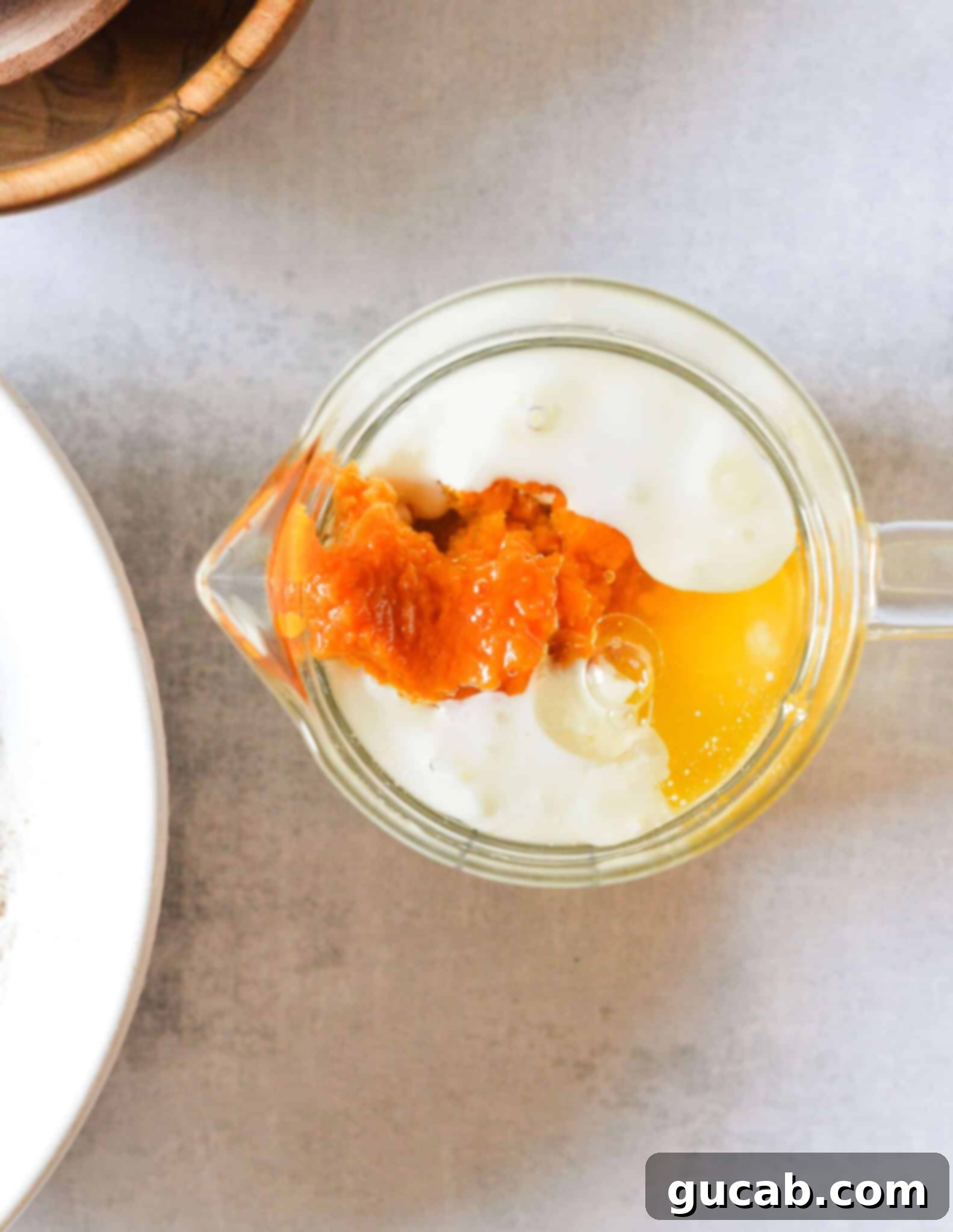 pumpkin puree, buttermilk, egg, and oil in a glass measuring cup. 