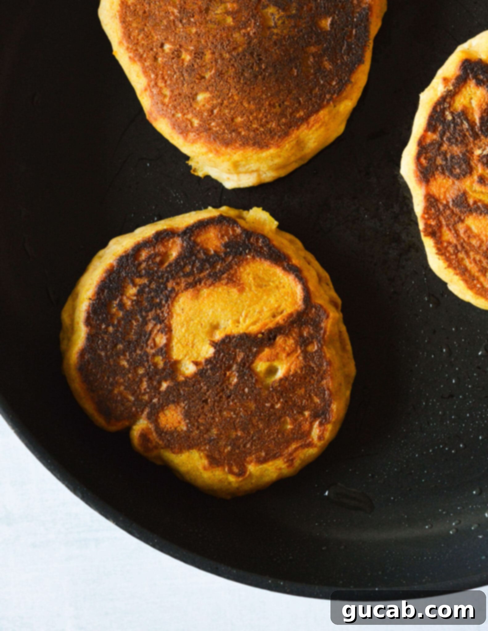 gluten free pumpkin pancakes in a skillet. 