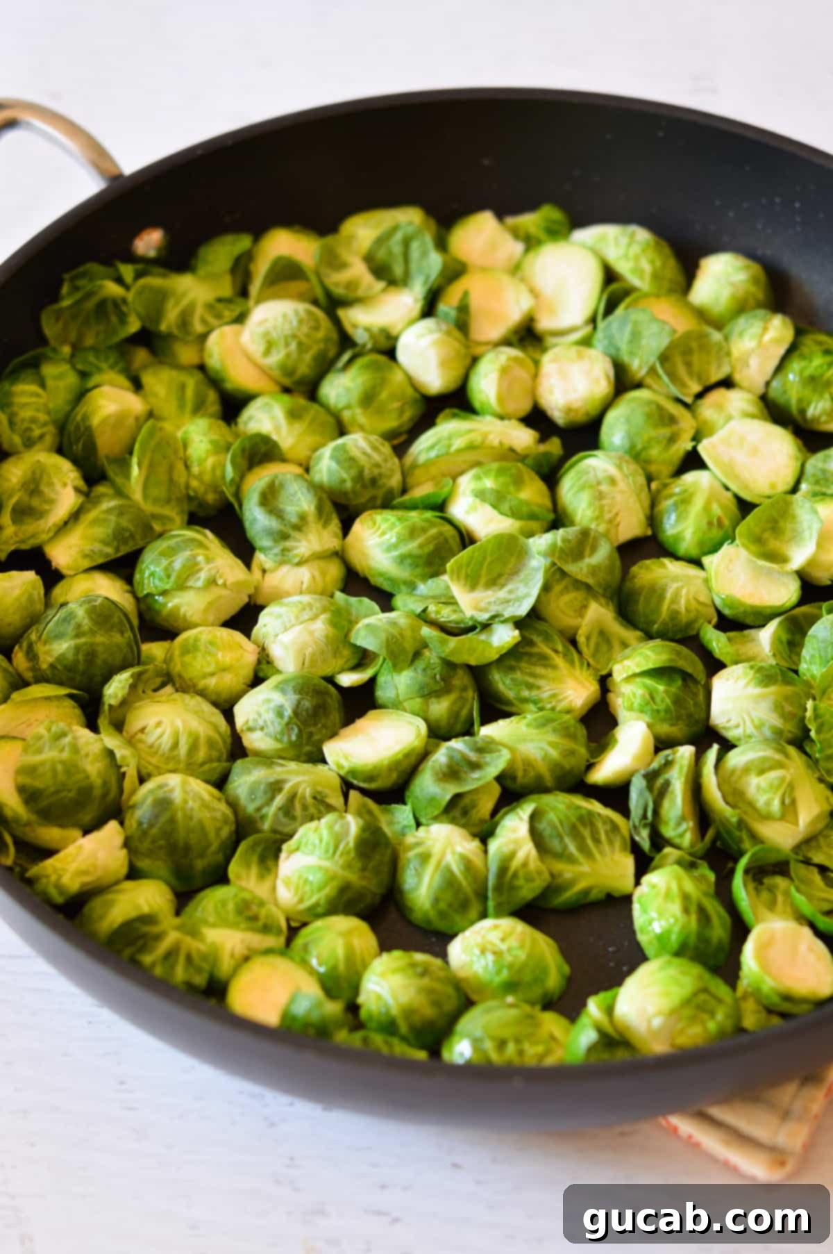 brussels sprouts cut in half laying in a skillet. 