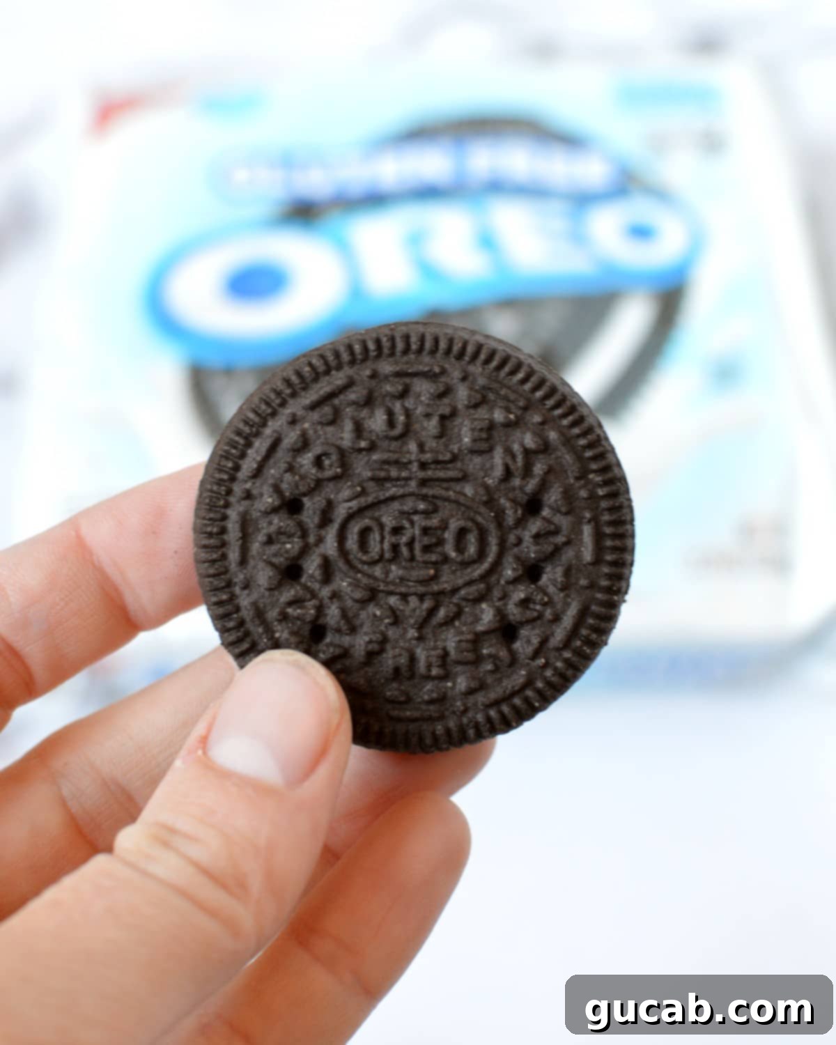 A single gluten free Oreo cookie with cream filling, twisted apart to show the two dark chocolate wafers.