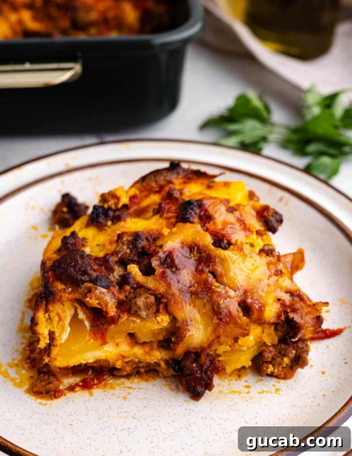 Gluten-Free No-Noodle Butternut Squash Lasagna 15 A close-up of a single slice of baked butternut squash lasagna on a white plate, ready to be enjoyed.