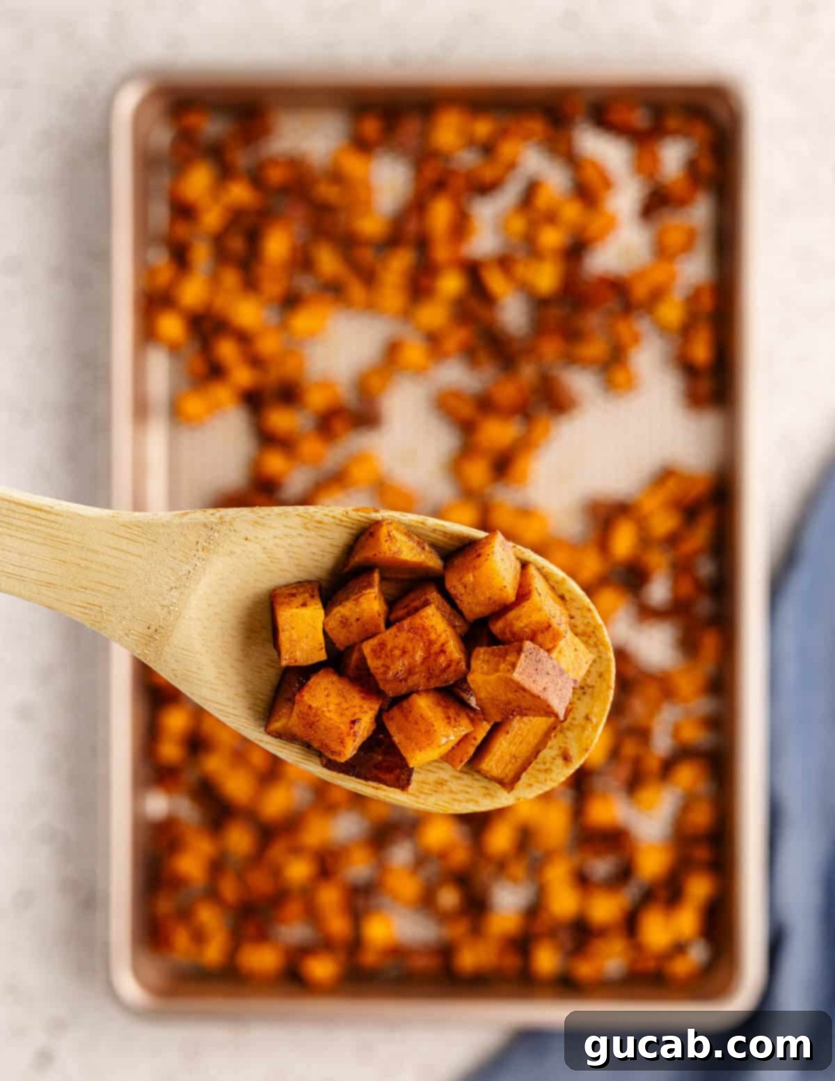 a wooden spoonful of roasted sweet potatoes. 