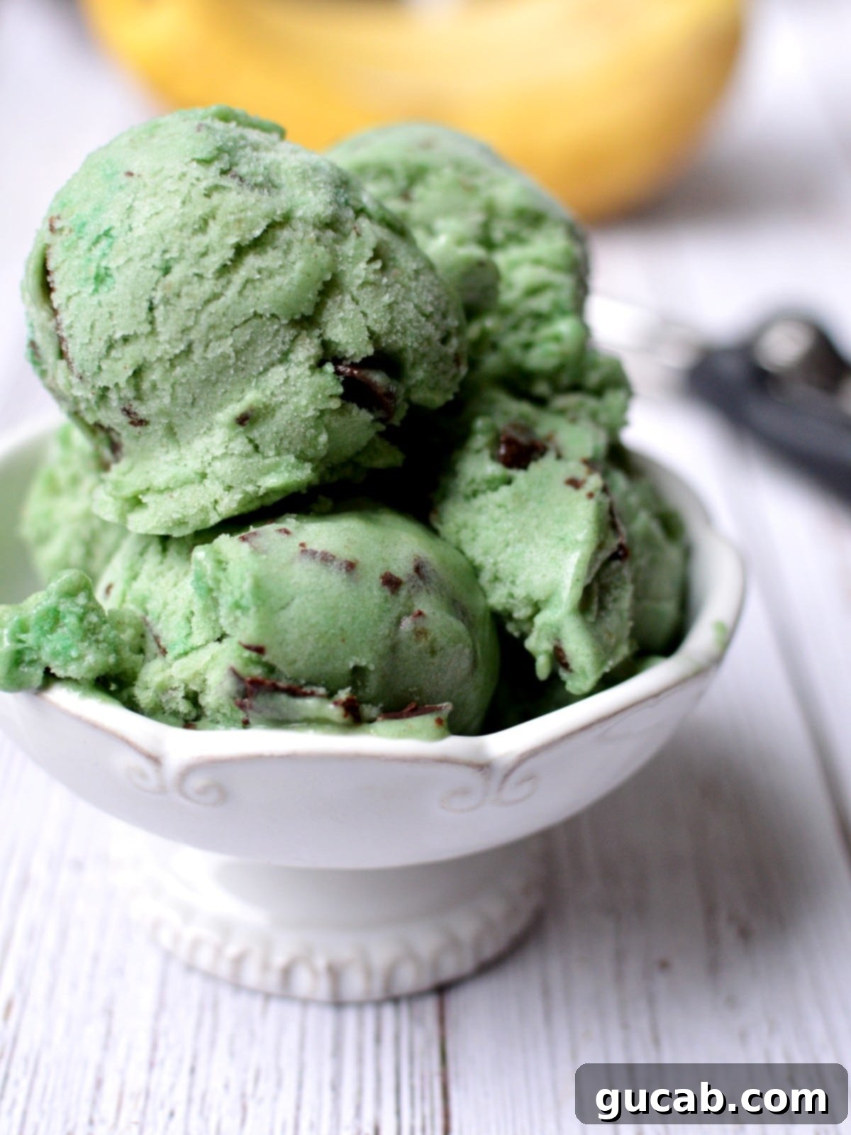 Close-up of freshly made mint chocolate chip nice cream with a spoon, showing its creamy texture and chocolate flecks.