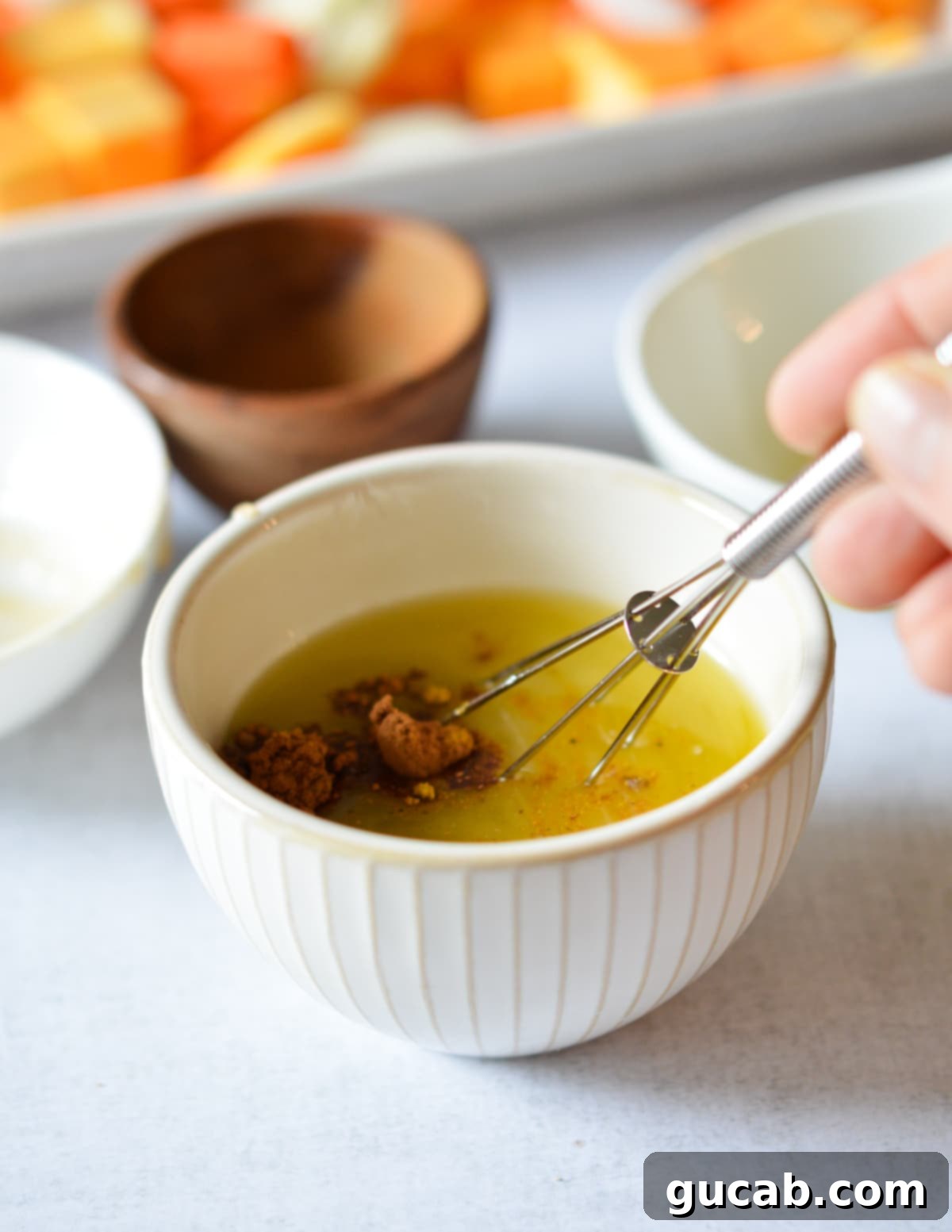 A small bowl containing melted butter, oil, brown sugar, and various spices, ready to be drizzled over vegetables.